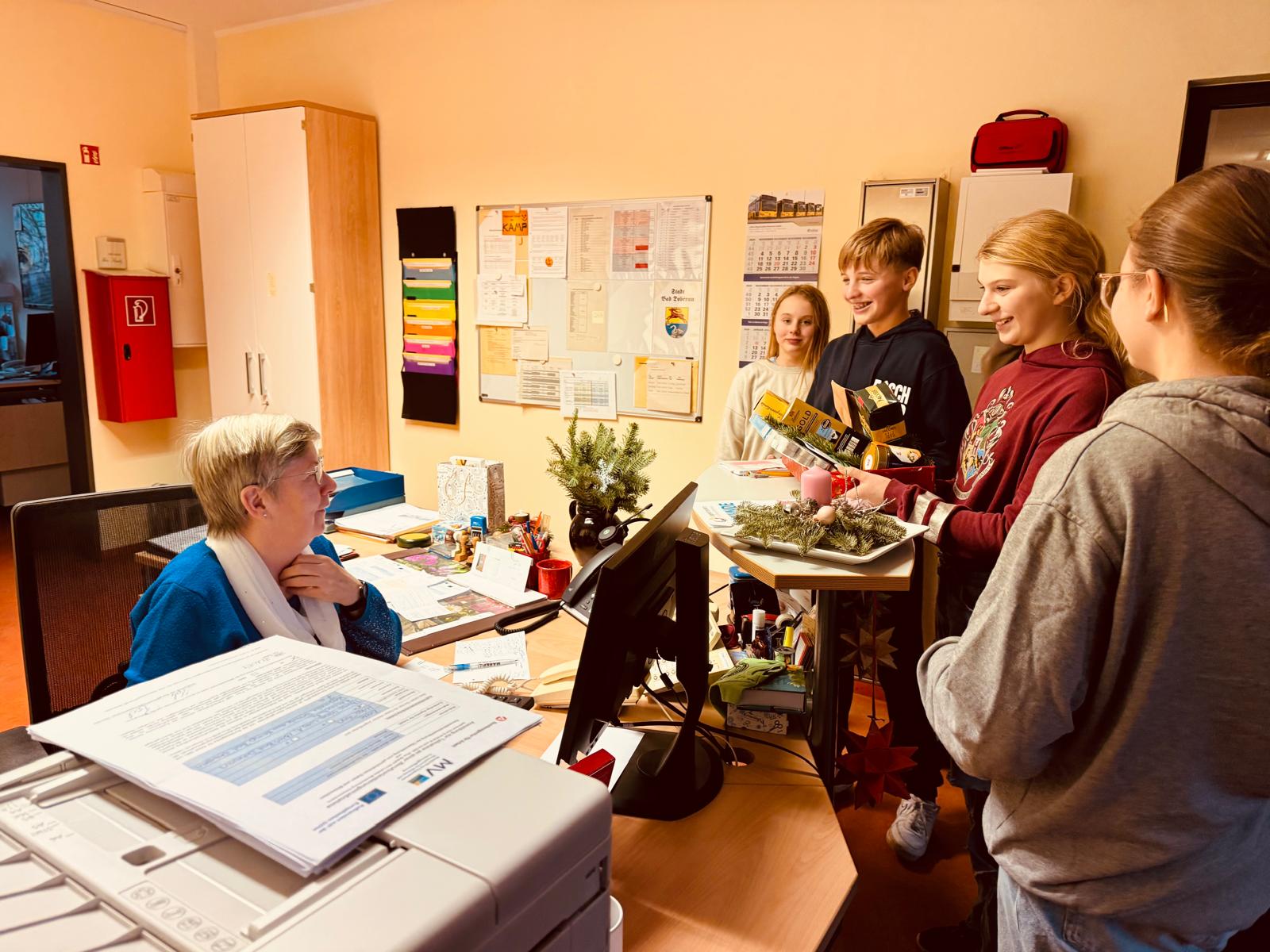 Schüler überreichen Dankeschön an Sekretärin zu Weihnachten